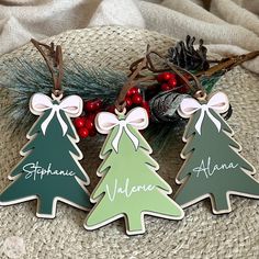 three wooden christmas trees with name tags on them