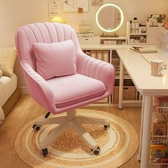 a pink chair sitting on top of a wooden floor in front of a desk with a mirror