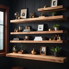 some shelves with plants and pictures on them in a room that has black painted walls