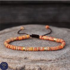 This delicate adjustable bracelet makes a wonderful gift for yourself, friend or loved one. The rope expands to easily slip onto any sized wrist and can be tightened to fit.            Orange Jasper beaded bracelet with gold plated alloy spacer beads , Natural Stones , Adjustable . Boho style       Jade size ; 2X4mm       Size :: Around 7 inches / 18 cm Adjustable bracelet with Orange Jasper beads and rose gold plated alloy spacer beads,   Jasper sustains and supports through times of stress, and brings tranquility and wholeness. It provides protection and absorbs negative energy.       Please note: All natural stone will have slight color difference. Each stone is unique in its color variations and texture due to the natural difference in the stones themselves.       Do not expose to chem Jasper Bead Bracelet, Tibetan Bracelet, Hippie Bracelets, Natural Stone Bracelets, Dainty Bracelets, Handmade Wire Jewelry, Jasper Beads, Boho Stil, Adjustable Bracelet