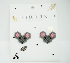 a pair of earrings with pink ears on them