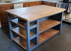 a kitchen island made out of wood with shelves on each side and an oven in the background