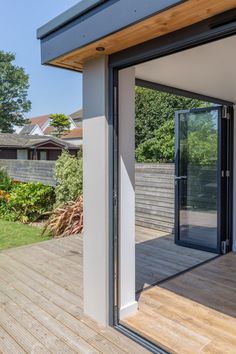 an open patio with sliding glass doors and wooden decking on the side of it