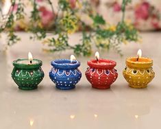 four colorful candles sitting on top of a table