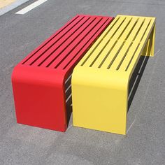 two brightly colored benches sitting in the middle of a parking lot next to each other