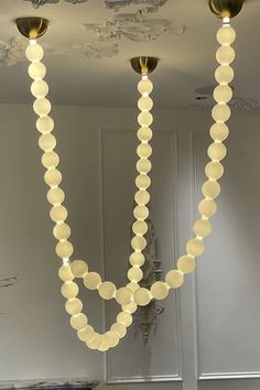 three lights are hanging from the ceiling in a room with white walls and flooring