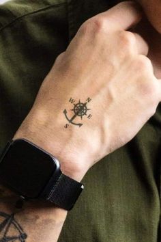 a man with a small anchor tattoo on his left arm and an apple watch in the other hand