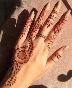 a woman's hand with henna tattoos on it