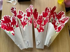 paper flowers with hand prints on them sitting on a table