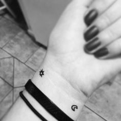 a black and white photo of someone's wrist with a small star on it