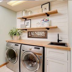 a washer and dryer in a small room with open shelving on the wall