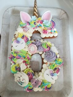 a cake shaped like the number five with unicorns and flowers on it, sitting in a pan