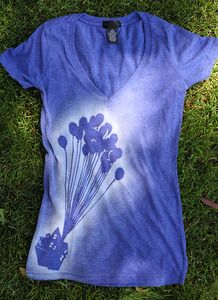 a blue shirt with balloons on it laying in the grass