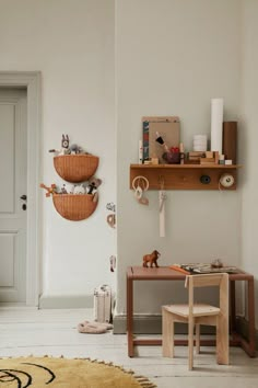 a child's room with toys and decor on the wall, including a desk