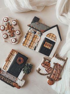 three decorated cookies sitting on top of a table next to candles and other items in front of them