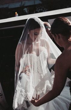 the bride is getting ready to walk down the aisle in her wedding dress and veil