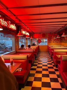 the interior of a diner with checkered flooring and neon lights on the ceiling