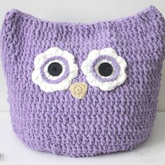 a purple knitted owl pillow with large eyes