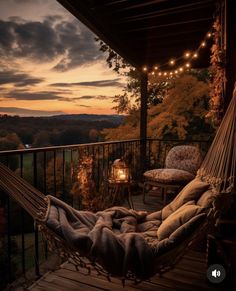 a hammock hanging from the side of a wooden deck next to a lamp