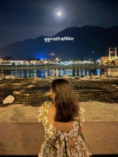 a woman sitting on a bench looking at the water