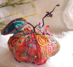 an orange decorative object sitting on top of a white cloth