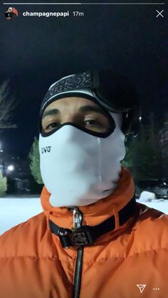 a man wearing an orange jacket and ski mask