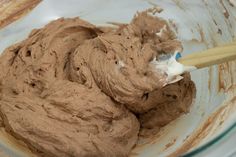 a mixing bowl filled with chocolate batter and a wooden spoon