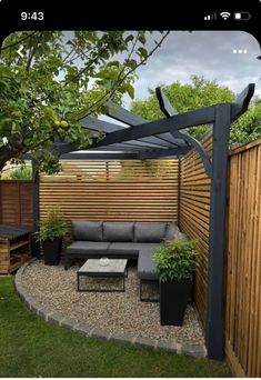 an outdoor seating area is shown in the backyard, with wooden fence and planters