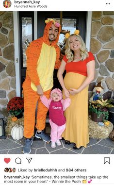 a man and woman in costumes standing next to a baby