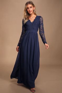 a woman in a long blue dress with lace sleeves and an open v - neck