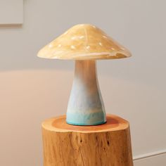 a ceramic mushroom sitting on top of a wooden table next to a white and blue wall