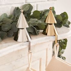 two christmas trees are sitting on the mantle