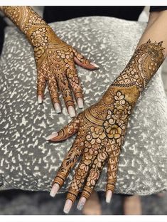 two hands with henna tattoos on them