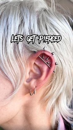 a woman with white hair and piercings behind her ear that says let's get pierced