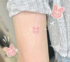 a person with a pink bunny tattoo on their arm and behind her are two small hearts