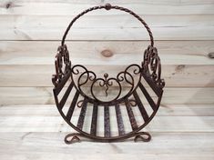 an old iron basket is hanging on a wooden wall with wood planks in the background