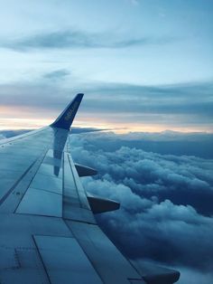 the wing of an airplane flying high above the clouds