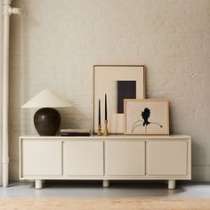 a white cabinet sitting next to a lamp on top of a hard wood floor