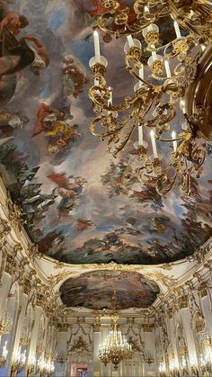 an ornate room with chandeliers and paintings on the ceiling