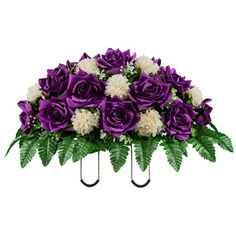 purple and white flowers are arranged in an arrangement on a metal stand with green leaves