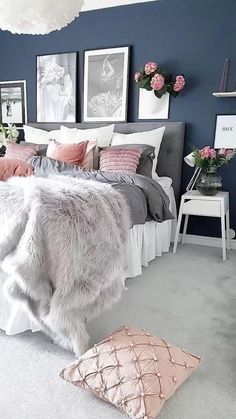 a bedroom with blue walls and white carpeted flooring is decorated in pink and grey