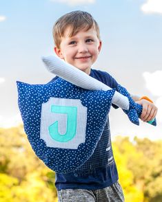 a young boy holding a baseball bat with the number 5 on it's back