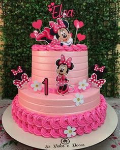 a pink cake with minnie mouse on top