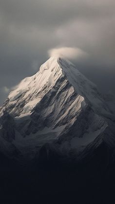 a snow covered mountain under a cloudy sky