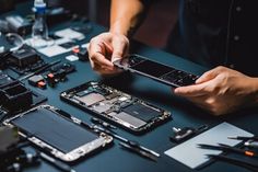 a man is working on his cell phone repair project with tools and other items around him