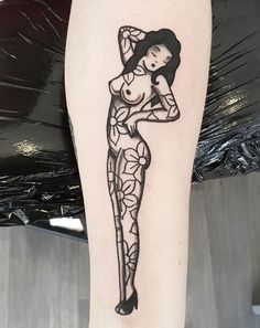 a black and white tattoo of a woman with flowers on her leg, holding an umbrella