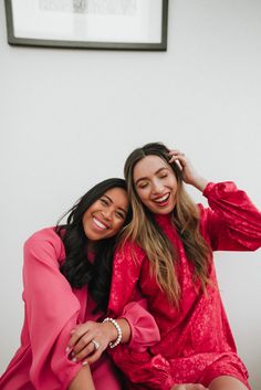 two women sitting next to each other smiling