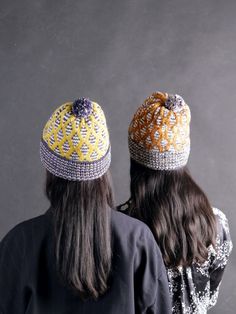 two people wearing hats standing next to each other