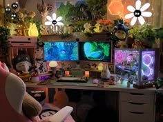 a desk with multiple monitors and stuffed animals on it