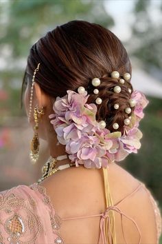 a woman with flowers in her hair and pearls on her head is wearing a pink dress